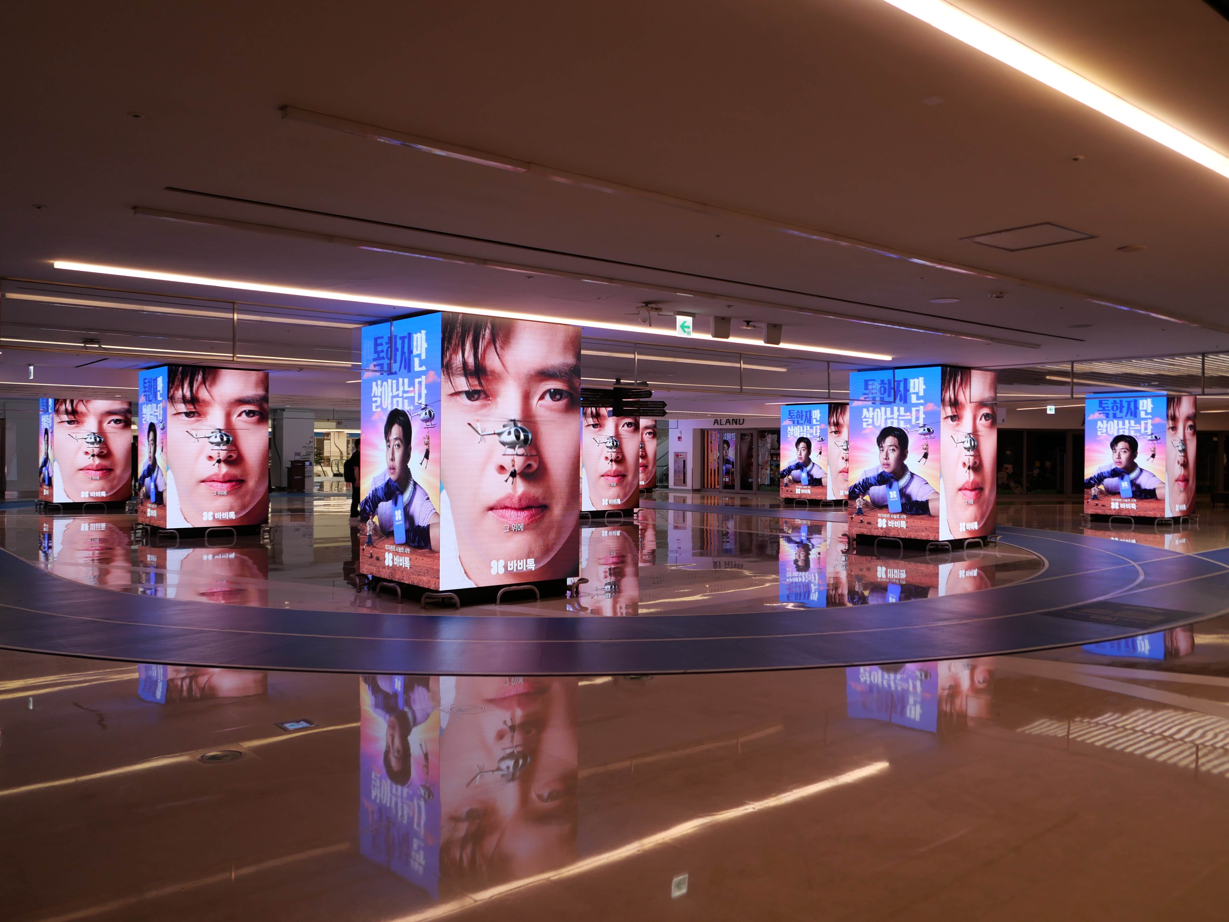 Ring of illuminated BABITALK digital cubes with alternating creative around the COEX 9TO9 plaza, Seoul