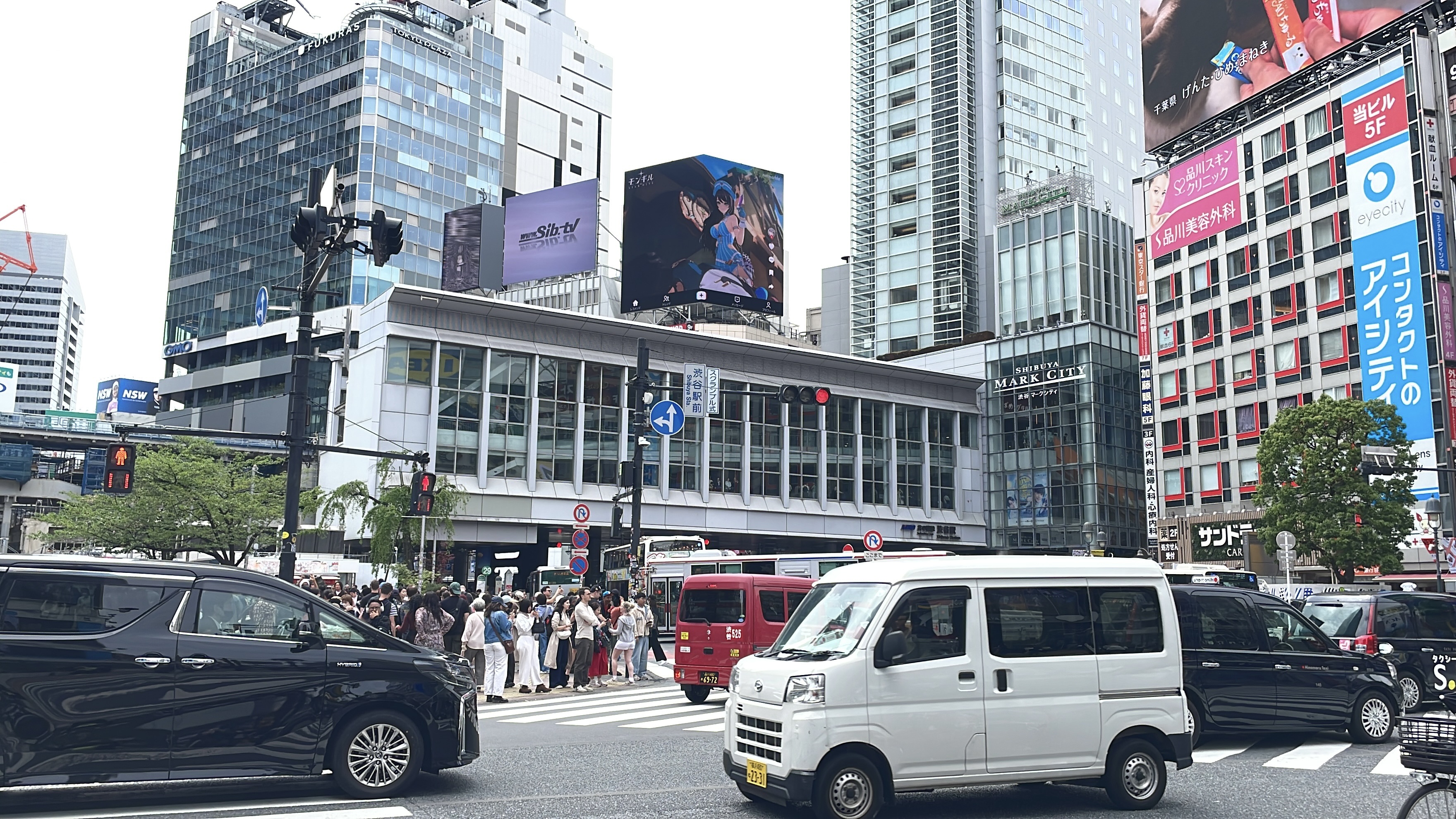MONGIL: STAR DIVE character creative on the rooftop screen above Shibuya Station and the waiting crowd, Tokyo