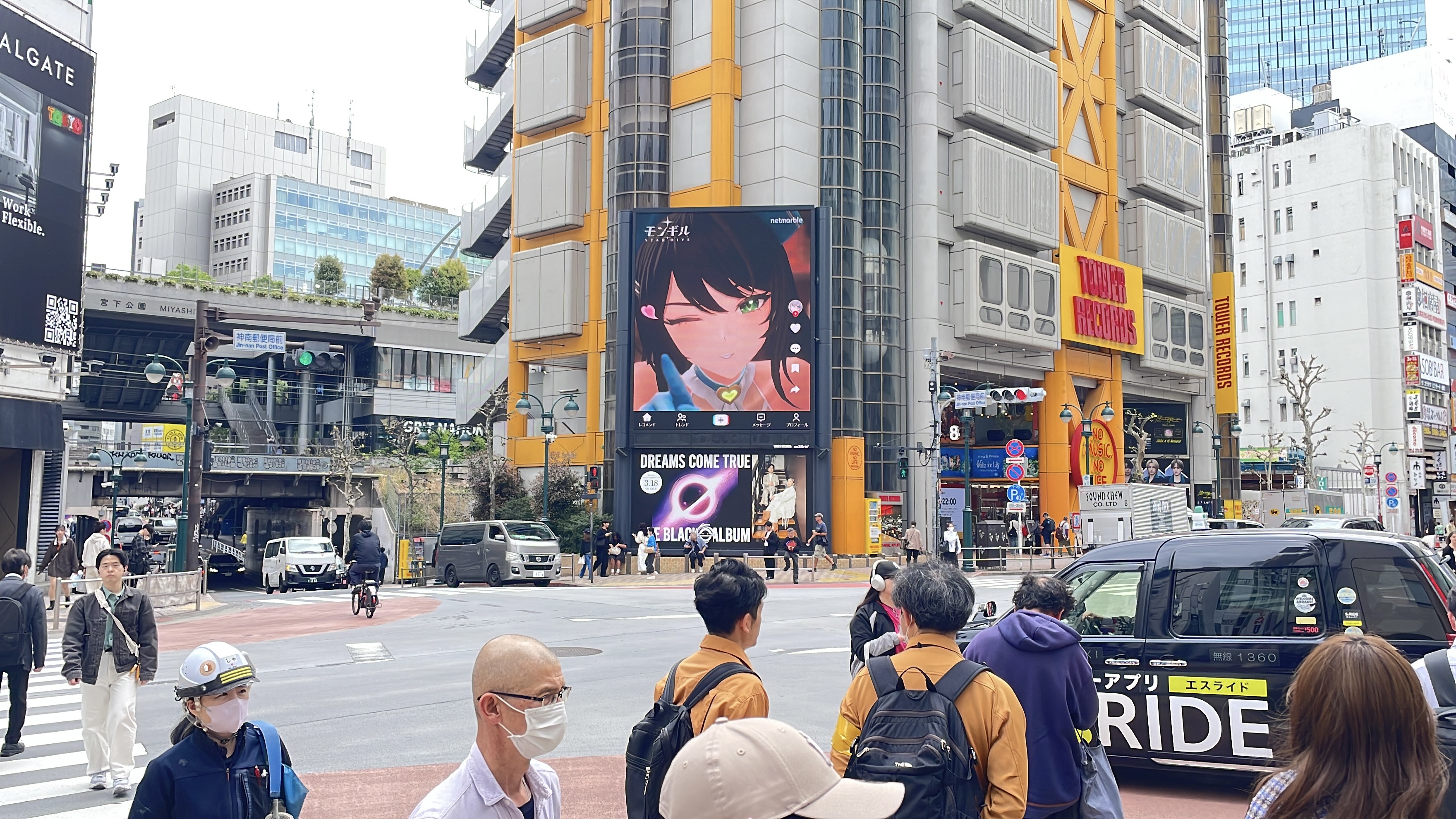 MONGIL: STAR DIVE character creative on the Tower Records Shibuya screen above a busy intersection, Tokyo