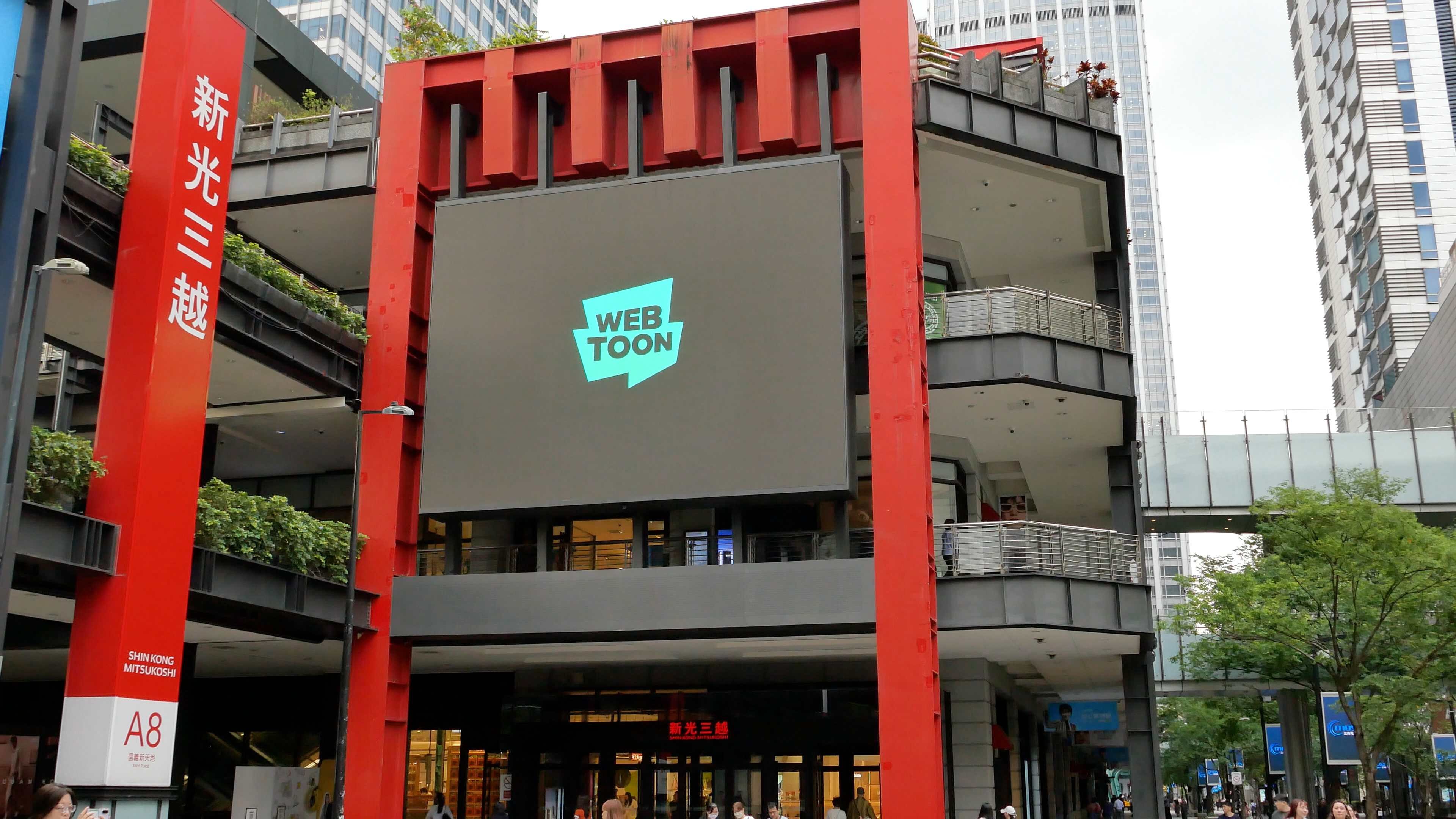 WEBTOON logo on the large digital screen framed by red columns at the Shin Kong Mitsukoshi A8 building, Taipei