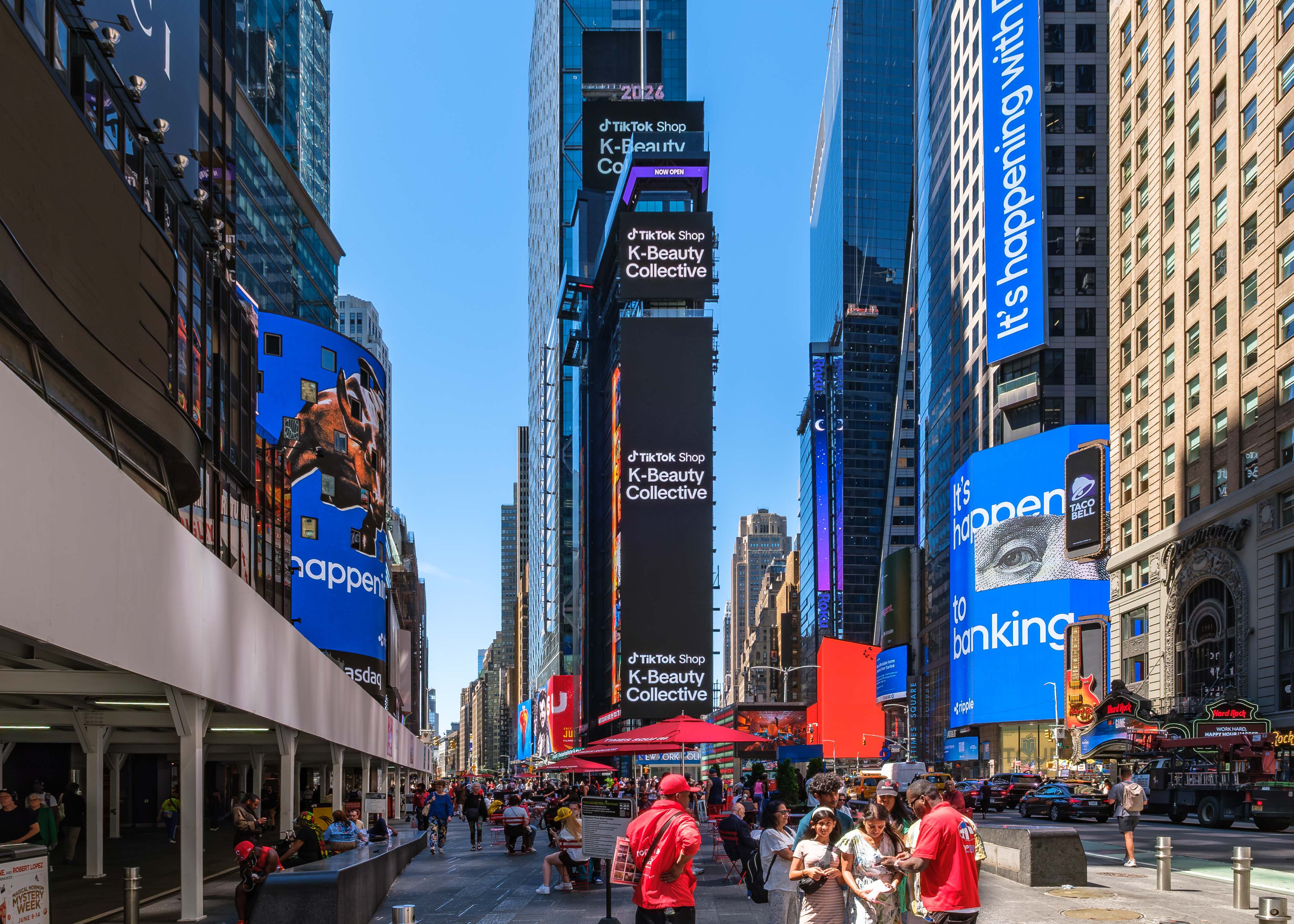 TikTok Shop K-Beauty Collective identity repeated across the full vertical Times Square placement on a sunny day