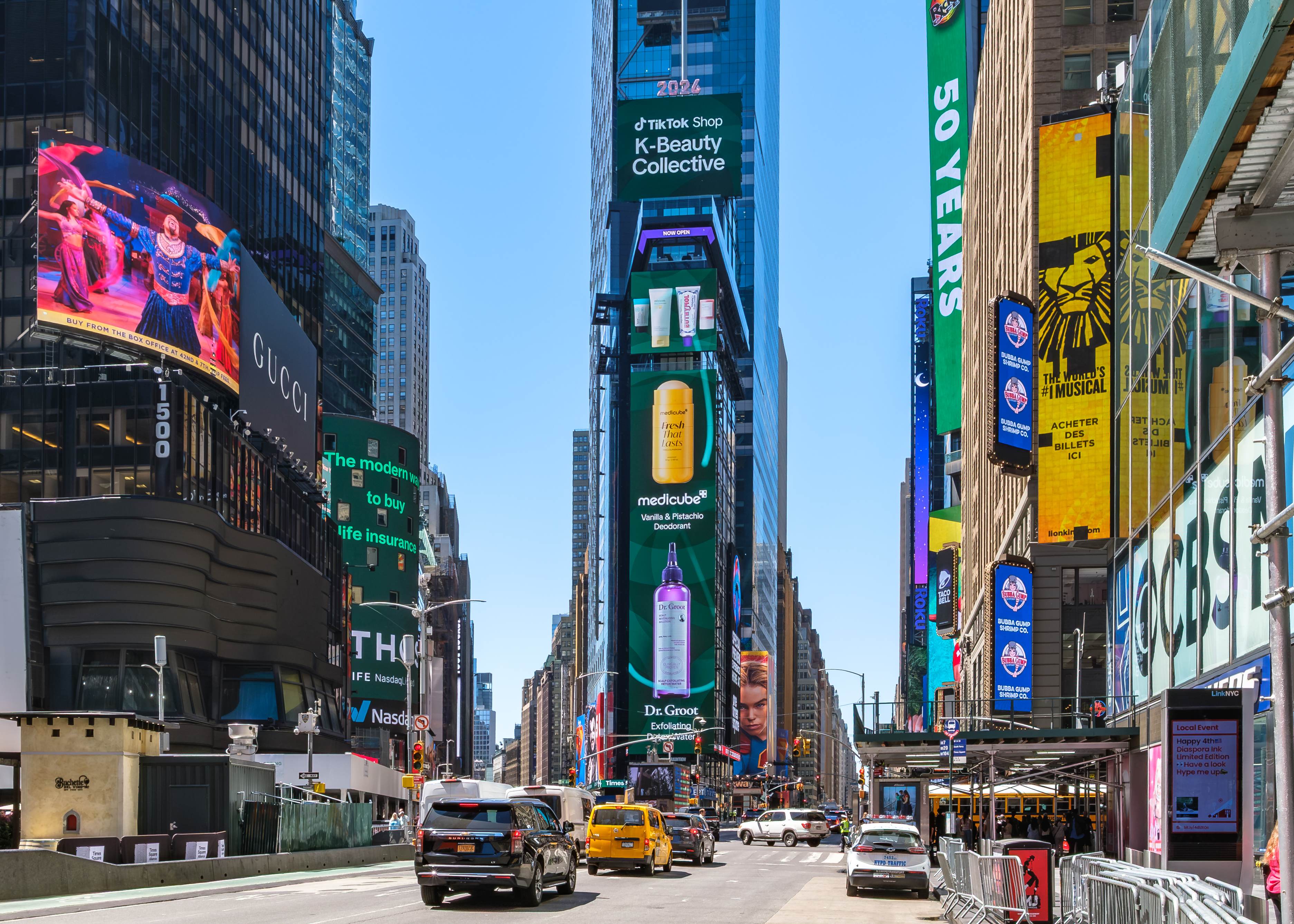 Alternate daytime angle of the vertical Times Square placement running medicube and Dr. Groot product creative