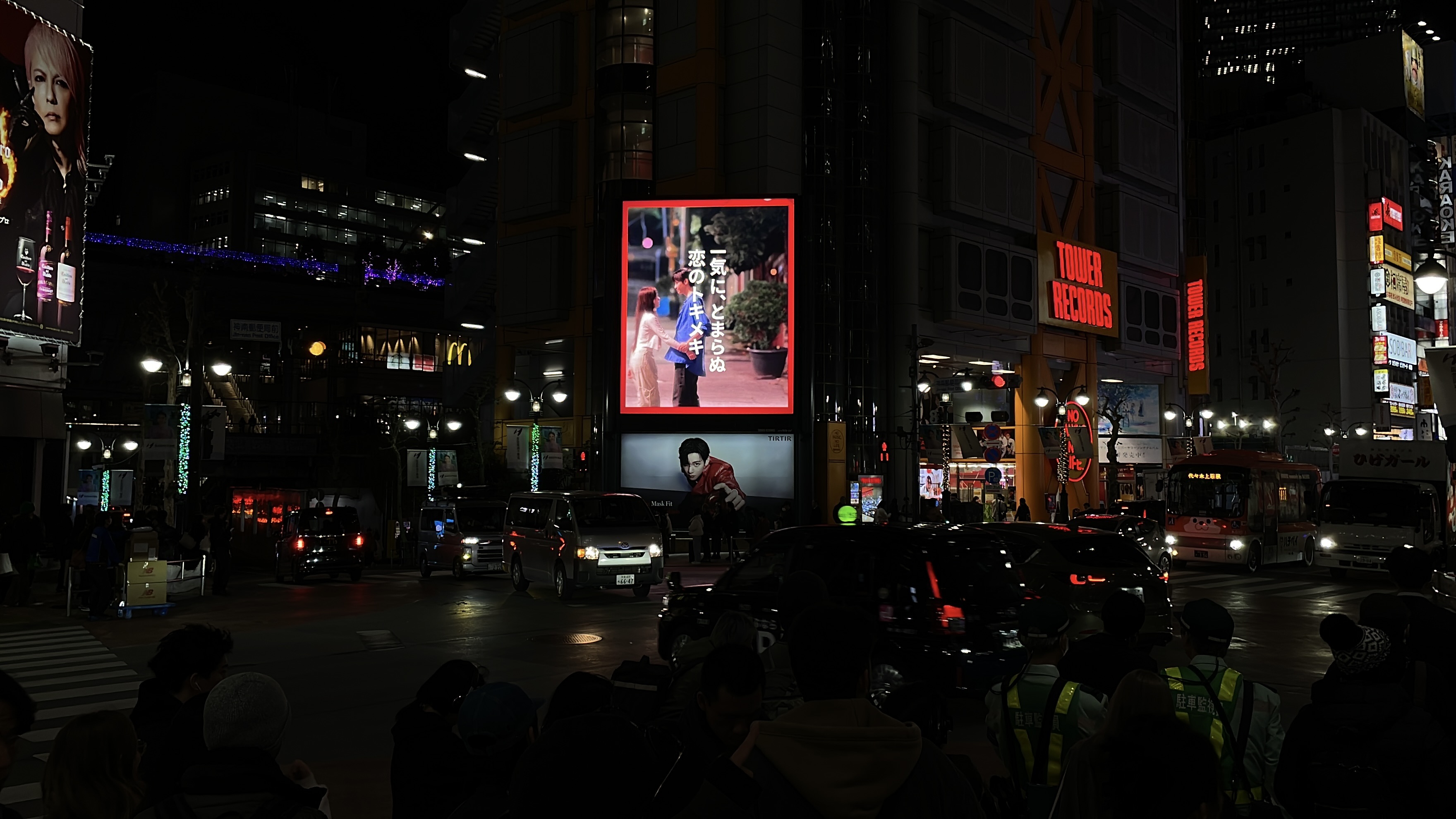 KANTA campaign on a red-framed digital screen beside Tower Records at night, Shibuya, Tokyo
